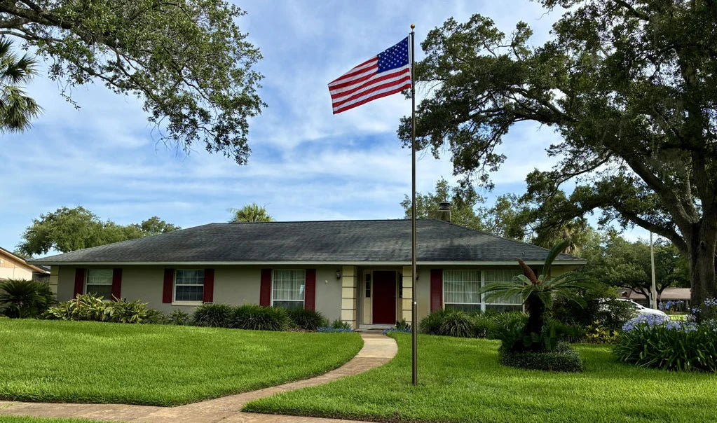 Customer photo: HD Telescoping Flagpole in bronze in front of a ranch home