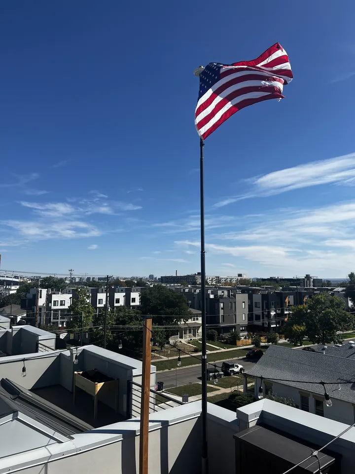 HD Telescoping Flagpole in anodized black on a city rooftop deck