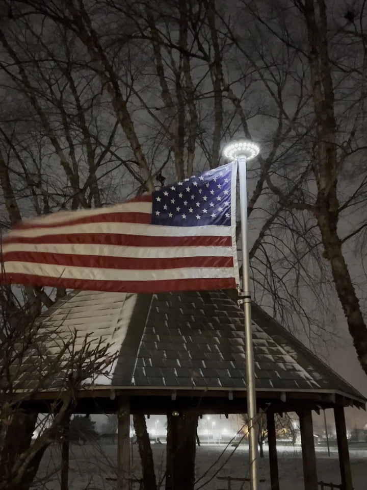 HD Telescoping Flagpole lit by the X40 solar light on a snowy winter night