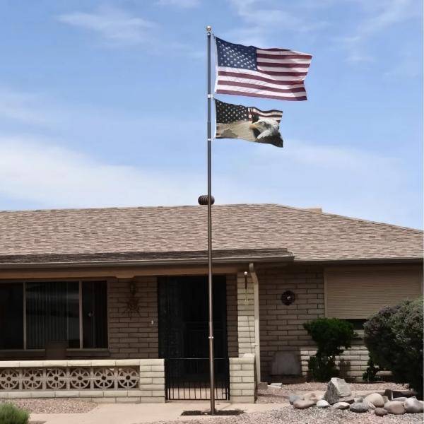 Bronze Liberty Telescoping Flagpole flying two flags in front of a ranch home