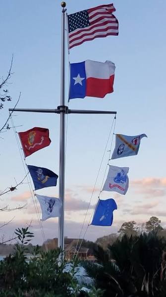 Nautical flagpole flying a Texas flag over signal flags