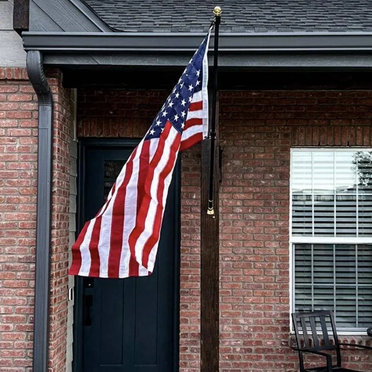 The American Flag flying from a porch post beside the front door