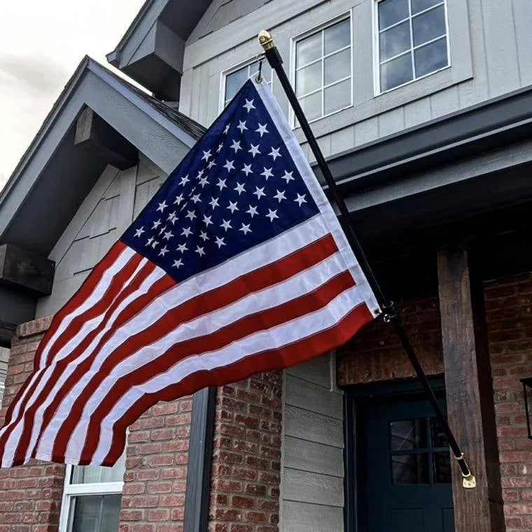 The American Flag flying from a house-mounted pole